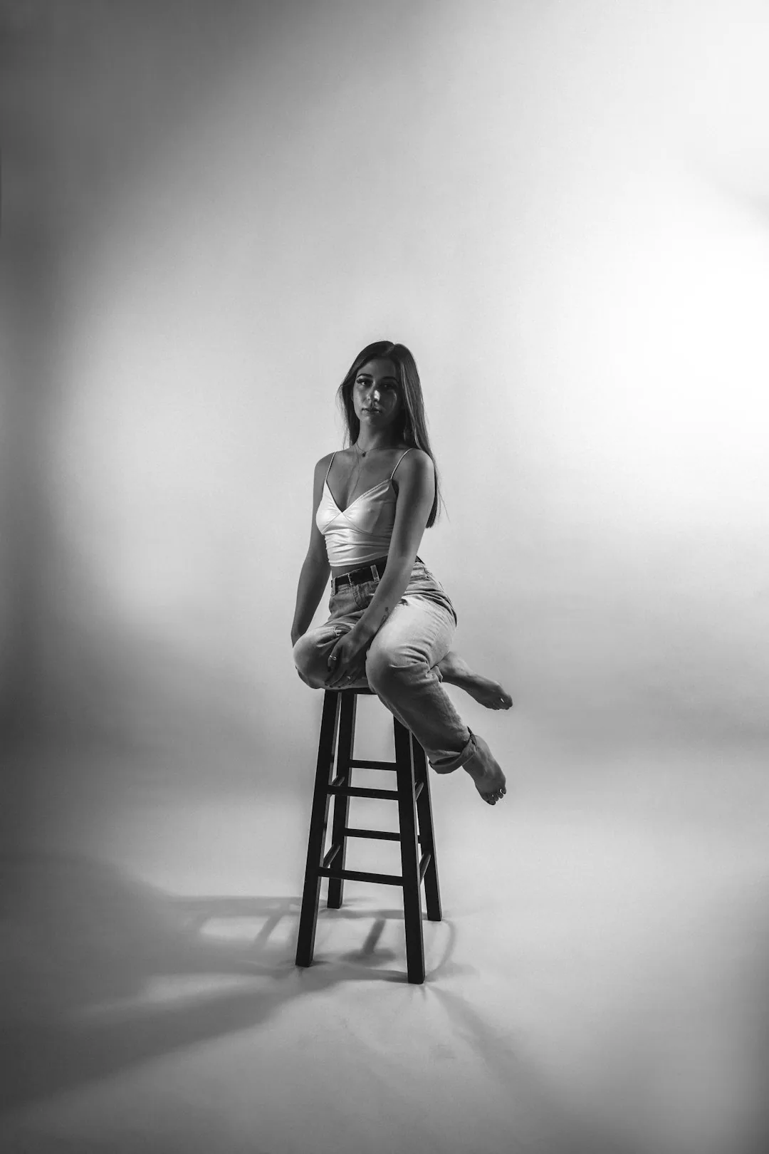 Portrait en studio en noir et blanc, sujet assis dans un cadre vertical aéré